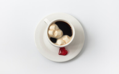 A Cup of coffee and marshmallows and a heart on a plate as a symbol of love
