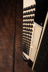 Old accordion on rustic wooden surface with black background and Low key lighting, selective focus.