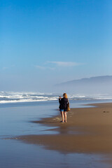 Naklejka premium Woman taking photo of the pacific ocean in Oregon with her smartphone