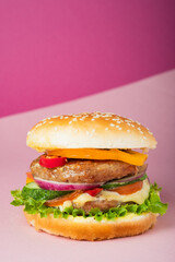 Fresh juicy beef hamburger placed on creative pink background with copy space, isometric vertical orientation