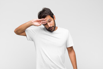 young latin handsome man looking stressed, tired and frustrated, drying sweat off forehead, feeling...