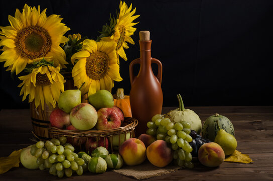 Still life with sunflowers from fruits, grapes and wine on a black background with copy space. Thanksgiving and harvest.