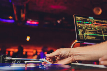 DJ playing vinyl musical record at hip hop party,festival.Concert in the nightclub.Professional...