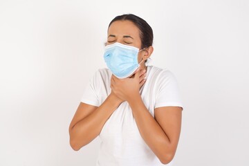 Young arab woman wearing medical mask standing over isolated white background shouting suffocate because painful strangle. Health problem. Asphyxiate and suicide concept.