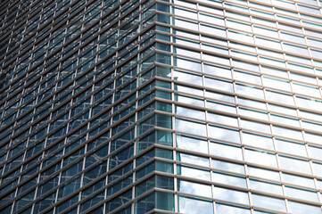 Skyscraper facade with glass facade and reflections.