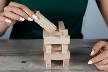 woman hand wooden cubes on table.