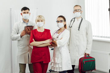 Fototapeta premium Portrait of young doctors standing in a row. Work of physicians during the quarantine of coronavirus