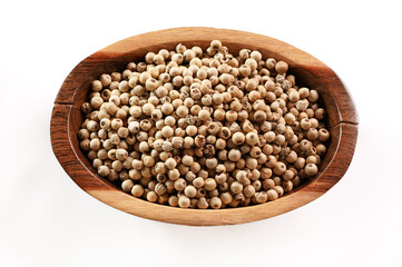 Dried white pepper corns in small wooden bowl - view form above isolated on white background