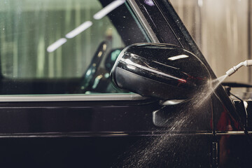 Close up of paint protection film installation on side mirror of modern luxury car. PPF is...