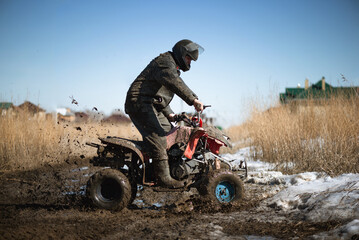 Biker on the quad bike is riding on the dirty road. © Dmitriy