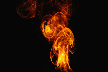 Orange smoke on a black background. Colored smoke. Smoke illuminated by orange light. Bizarre spellbinding flames.