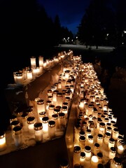Snowy graveyard by night lit up by candles in memory of the dead in the snow outside of Helsinki in...