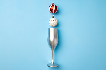 Champagne glass with Christmas balls flat lay