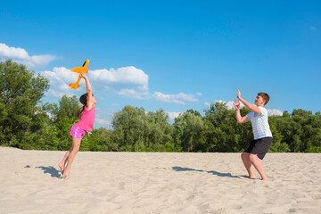 Children play in the sand on a sunny day. Sports games during the summer holidays. Holidays, sports, leisure, lifestyle.