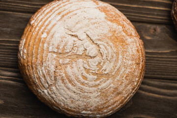 top view of fresh baked white bread loaf on wooden surface