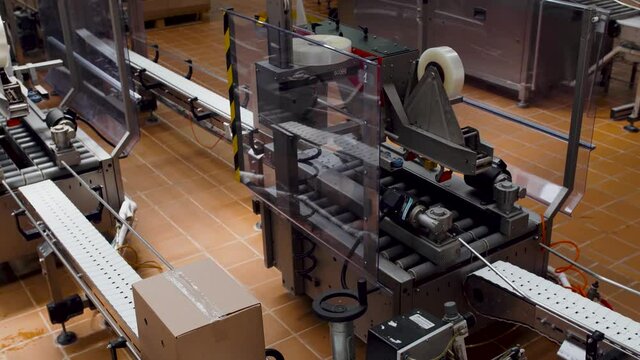 Smart automated warehouse box sealing system tapes packages on conveyor roller for shipping