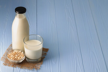 Vegan oat milk with oat flakes close up