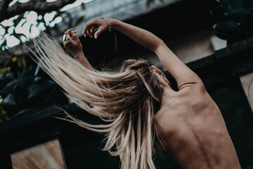Portrait of young model with  boho accessories. Beautiful  girl from the back tossing hair in air and enjoying fresh air in outdoor. Concept of hippie free lifestyle.