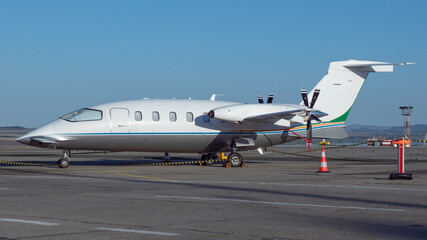 Side view of white business airplane with twin turboprop engines mounted in pusher configuration....