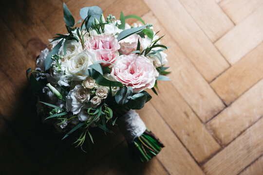 Front view of beautiful wedding bouquet made of pink, white rose and eucalyptus on wooden floor. Charming fresh bunch of flowers for romantic date, presented gift at valentines day. Concept of beauty.