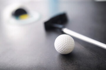 Sport and healthy lifestyle. Mini golf. White golf ball and set for minigolf on the table. Sports background with golf concept.