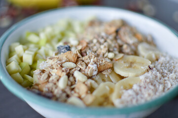 Fruit bowl with banana, apple and oatmeal for breakfast.