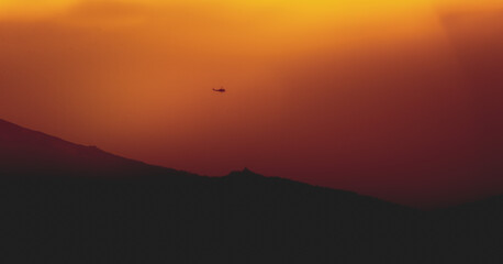 Helicopter in mountains with fire smoke