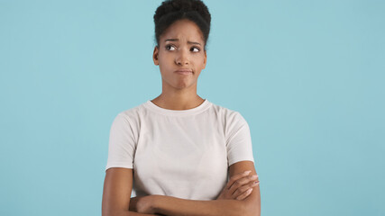 Upset african american girl holding arms crossed thoughtfully looking aside isolated