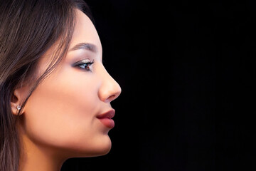 Fototapeta premium Close up portrait in profile of young beautiful woman with smoky eye makeup