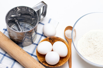 Fototapeta na wymiar making dough for bread or homemade baked goods. ingredients on the table: eggs, flour, salt, rolling pin