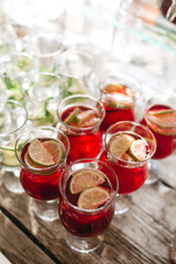 Top view of delicious sangria cocktail, lime slices on wooden table. Fresh juice on sober party time. Drink bar on wedding celebration. Simple bartender recipes. Concept of health and delicious food.