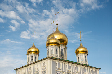 Fototapeta na wymiar Golden domes and crosses of Orthodox church in Tula against blue sky