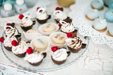 Close up of sweet chocolate cupcake and macaron on wedding celebration. Delicious patisserie and complicated recipes at bakery. Yummy candy bar on baby shower. Concept of tasty calorie food, keto diet