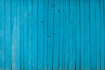 Fototapeta na wymiar Wall of wooden planks of blue color with cracks. Background for design.