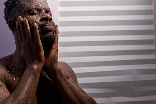 close-up photo of young afro american man washing face in shower, hygiene and bodycare, skincare concept - Powered by Adobe