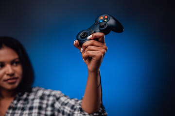 Modern gaming entertainment and sport field. Feminine blackskinned hand holds gaming device in...