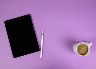 Tablet and electronic pen with a cup of coffee on a purple background. Template blank. A glass of coffee. Break at the office.