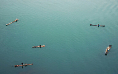 Fototapeta na wymiar Aerial view of the Li River in Guilin, Guangxi Province, China taken from the summit of Mt Diecai. Unidentifiable fishermen float on bamboo rafts on the blue waters of the Li River. Fishing in Guilin.