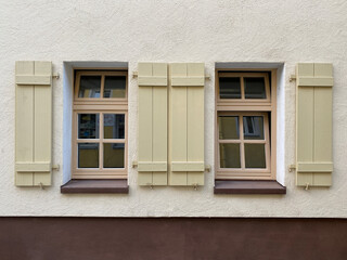 Zwei Fenster parall nebeneinander, beide mit hellgrünen offenen Fensterläden