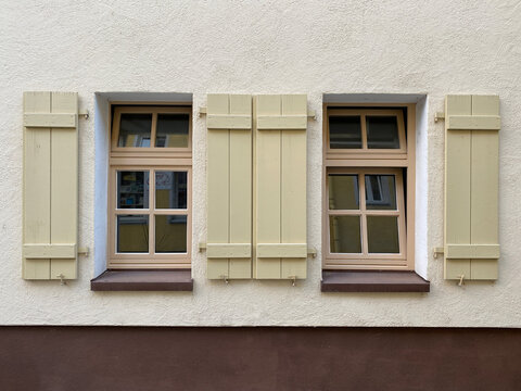 Zwei Fenster parall nebeneinander, beide mit hellgr&uuml;nen offenen Fensterl&auml;den