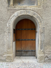 Tür, Rundbogen, schwere Holztür mit Eisenbeschlägen, Kopfsteinpflaster