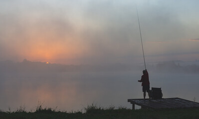 .Fishing at dawn Fisherman on the background of the morning sky
