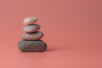 Stack of  Zen pebbles on a pink background