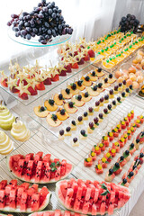 Top view of sliced exotic fruit assortment on wedding catering. Piece of fresh watermelon, peach, pear, orange. All inclusive on vacation. Sweet birthday buffet in restaurant. Concept of healthy food.