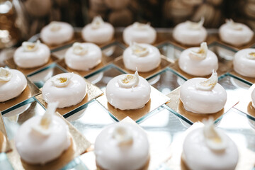 Close up of white decorated mousse desserts on table. Lesson of cooking candy, cupcake and sweet patisserie, masterclass. Sugar free desserts, keto diet. Concept of unhealthy food and yummy bakery.