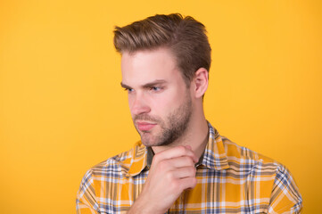 Handsome caucasian man with unshaven face skin and stylish hair yellow background, skincare
