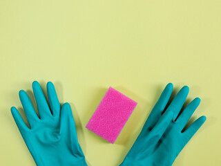Rubber gloves and a sponge.
Green rubber gloves and a pink sponge lie on a yellow background with a...