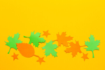 autumn maple leaves. Autumn leaves made of paper on a yellow background. Greeting card, autumn season concept. Top view, flat styling, copy space