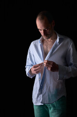 Hombre abrochando la camisa.