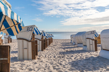  beach chairs stand on the beach of the Baltic Sea and the sky is blue